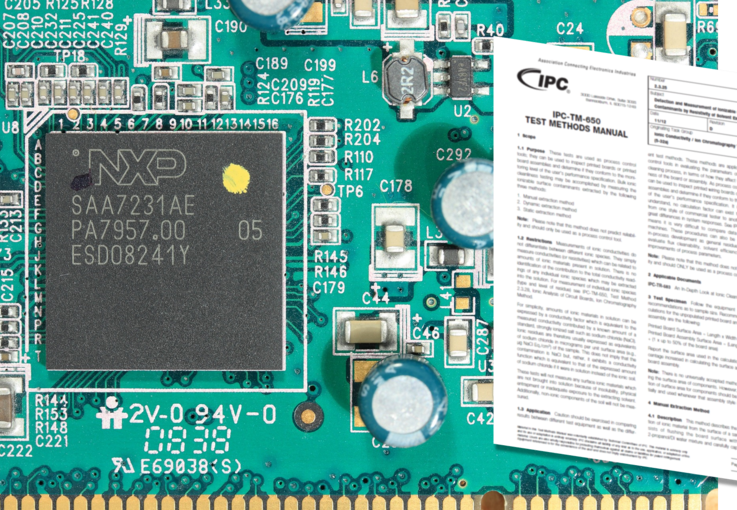 Grüne Leiterplatte, rechts daneben ein weißes Blatt mit Informationen zu 'IPC-TM-650 Test Methods Manual'.